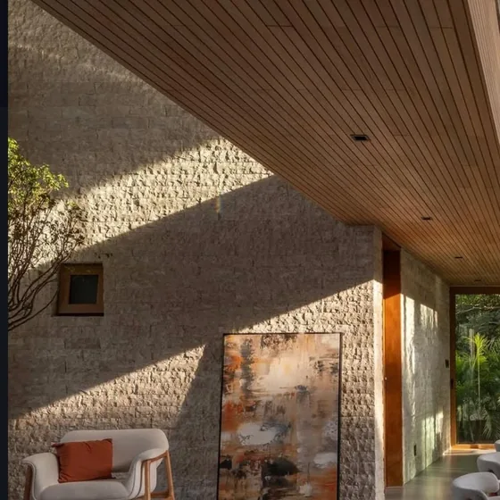 Sala com pedra natural e teto ripado em madeira