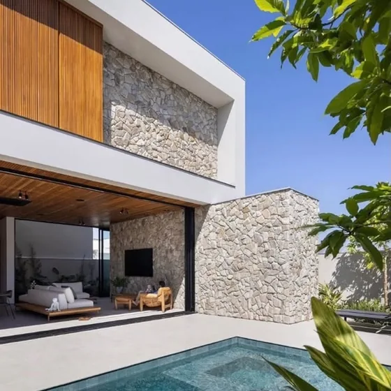 Residência com fachada em pedra e piscina